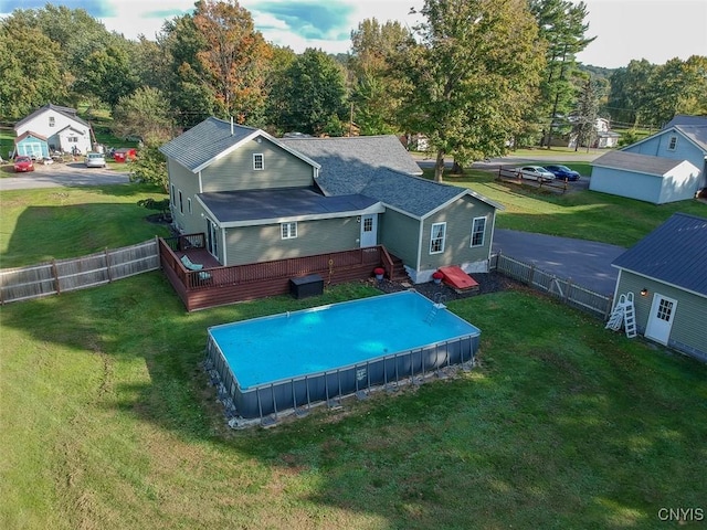 back of property featuring a lawn and a swimming pool side deck