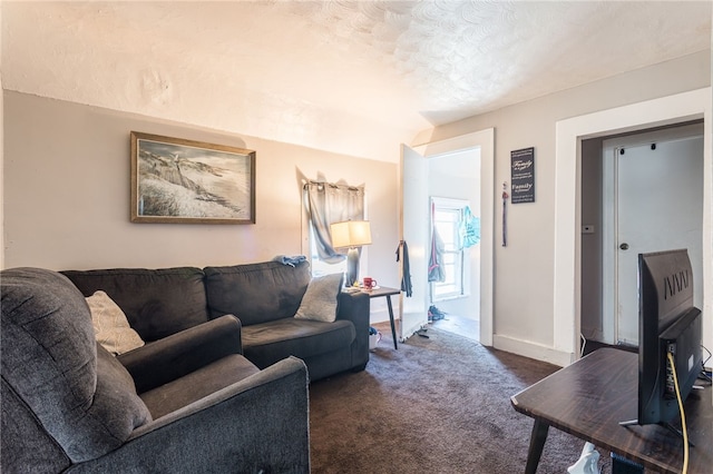 living room featuring dark carpet and a textured ceiling