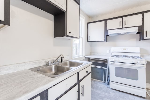 kitchen with sink, white gas stove, and white cabinetry