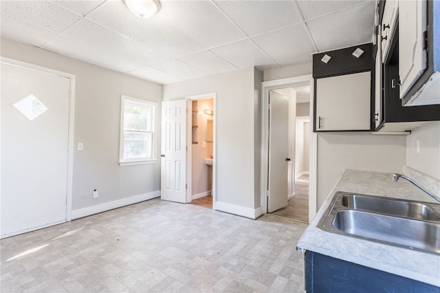 kitchen featuring a paneled ceiling and sink