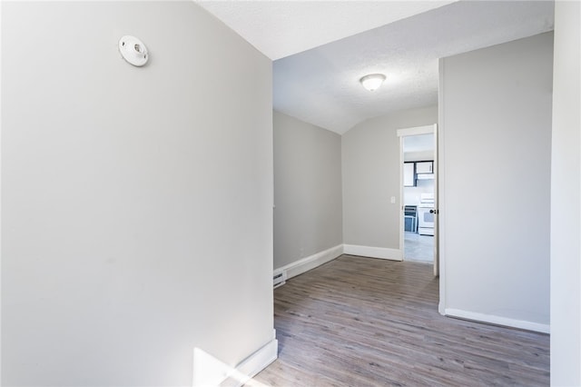 hall featuring wood-type flooring, a textured ceiling, and vaulted ceiling