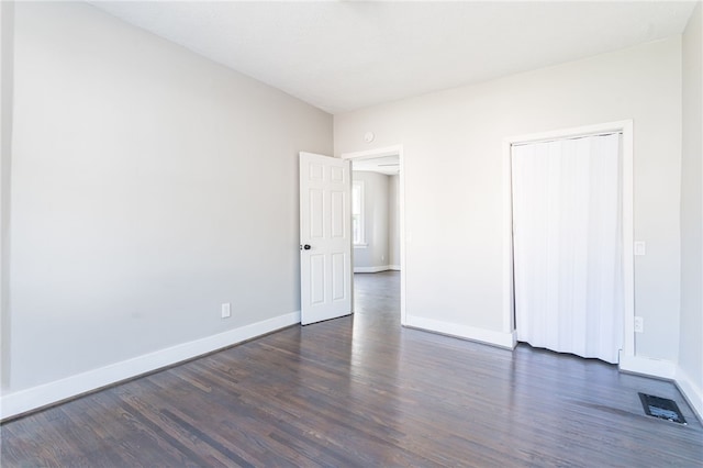 unfurnished bedroom with a closet and dark hardwood / wood-style flooring