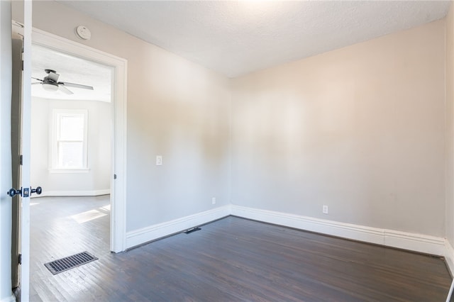 empty room featuring ceiling fan, a textured ceiling, and dark hardwood / wood-style floors