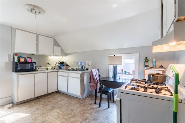 kitchen with vaulted ceiling, sink, white gas stove, and white cabinets