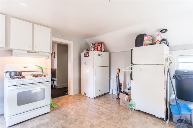 kitchen featuring white appliances, white cabinetry, lofted ceiling, and light tile patterned floors