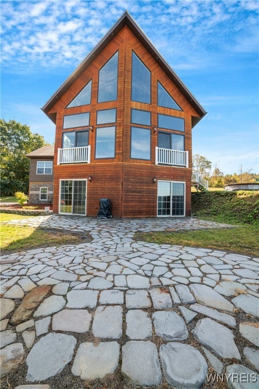 back of house with a balcony and a patio area