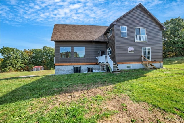 rear view of property featuring a lawn and a shed