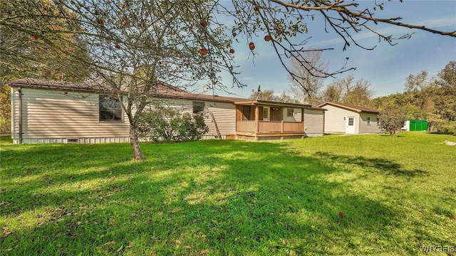 rear view of house with a lawn and a deck