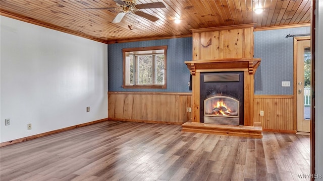 unfurnished living room featuring wooden walls, wood ceiling, a fireplace, and hardwood / wood-style floors