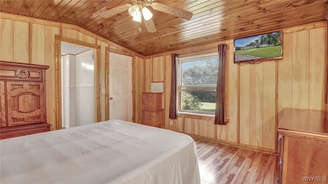 bedroom featuring wood ceiling, light hardwood / wood-style floors, vaulted ceiling, ceiling fan, and wooden walls