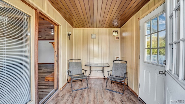 sitting room featuring wooden walls, wooden ceiling, and hardwood / wood-style floors