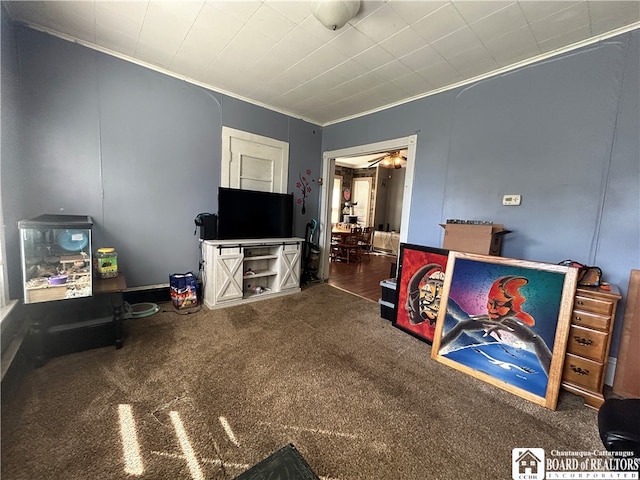 game room with ceiling fan, ornamental molding, and dark carpet