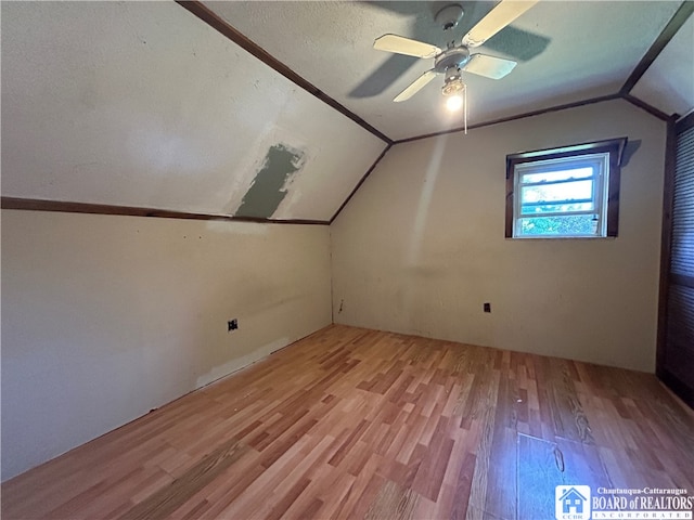 bonus room featuring ceiling fan, a textured ceiling, light hardwood / wood-style flooring, and vaulted ceiling