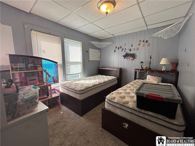 bedroom with a drop ceiling and carpet floors