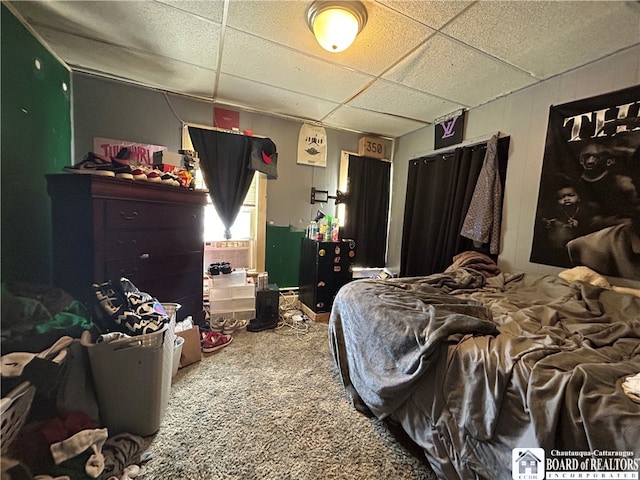 bedroom featuring carpet floors and a drop ceiling