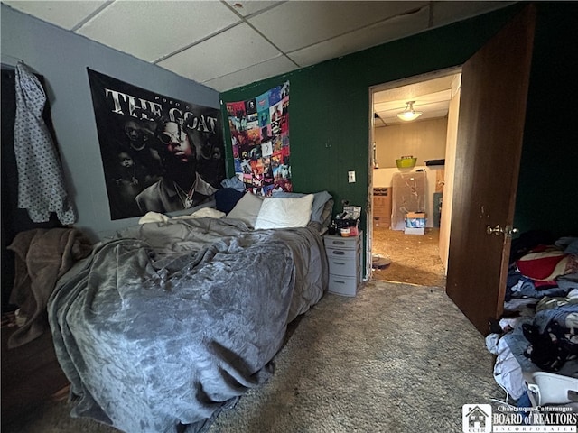 bedroom with a drop ceiling and carpet floors