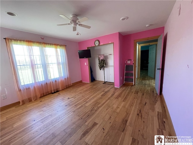 unfurnished bedroom with a closet, hardwood / wood-style flooring, and ceiling fan