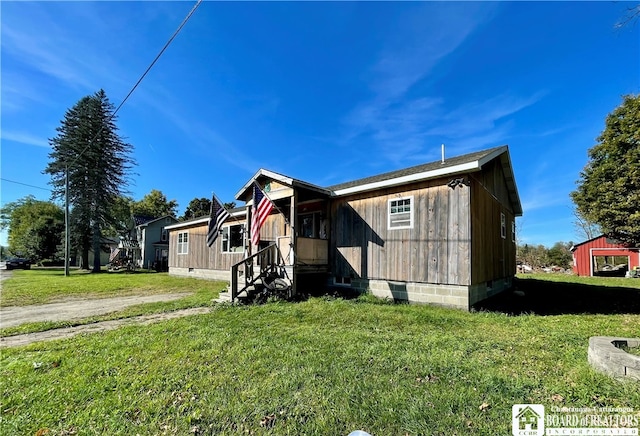 view of front of house with a storage shed and a front yard