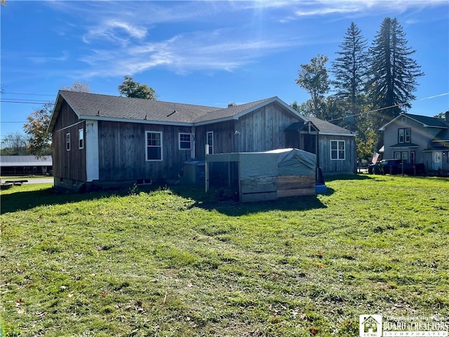 rear view of property featuring a yard