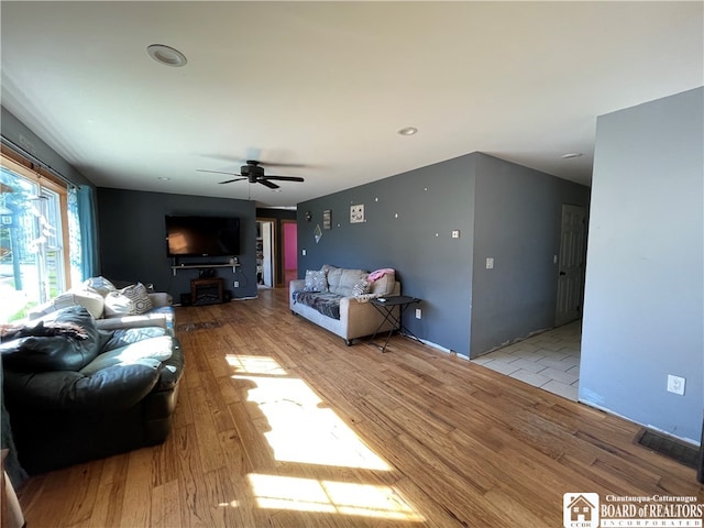 living room with light wood-type flooring and ceiling fan