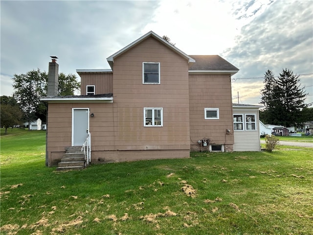 rear view of house featuring a lawn