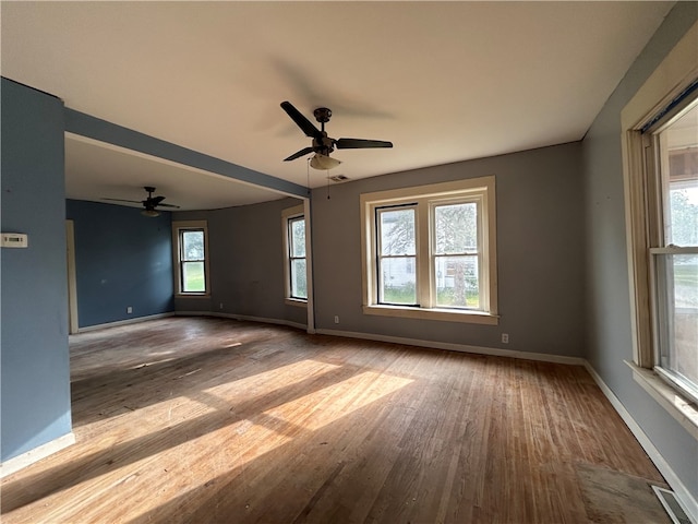 unfurnished room featuring ceiling fan, light hardwood / wood-style floors, and a healthy amount of sunlight