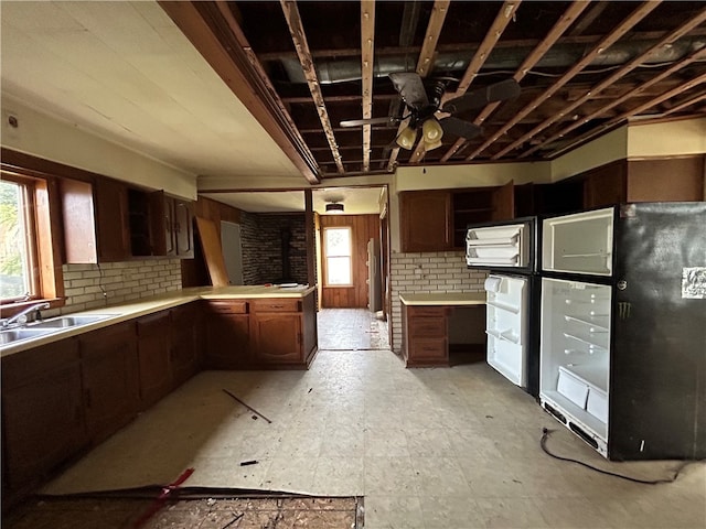 kitchen with decorative backsplash, ceiling fan, refrigerator, and sink