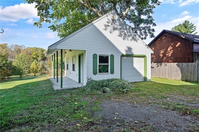 rear view of property with a garage and a lawn