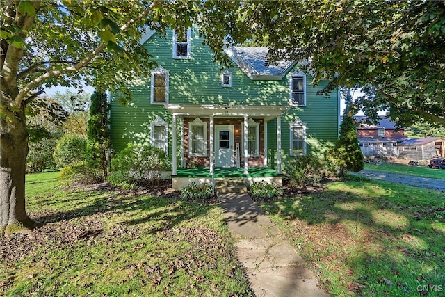 view of front of property featuring covered porch and a front yard