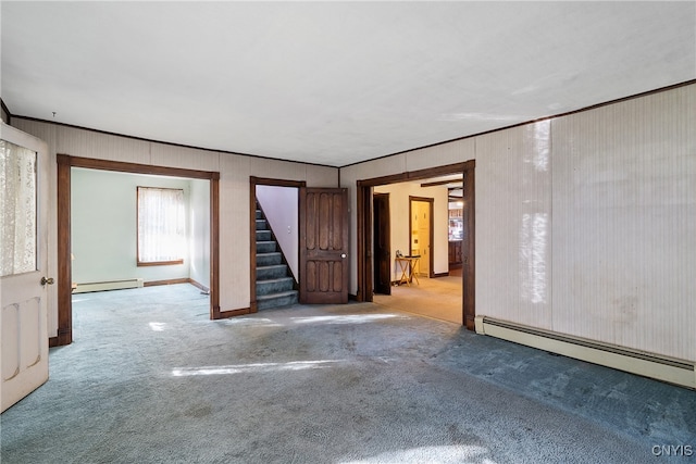 spare room with a baseboard heating unit, light colored carpet, and crown molding