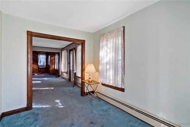 carpeted empty room featuring baseboard heating