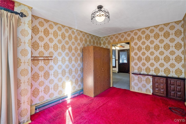 spare room with carpet floors, baseboard heating, and ceiling fan