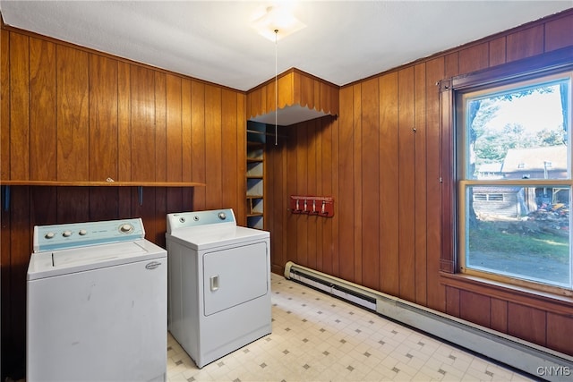 washroom featuring separate washer and dryer, wooden walls, and baseboard heating