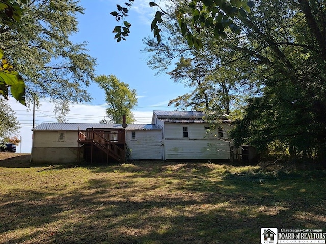 rear view of house featuring a deck and a yard