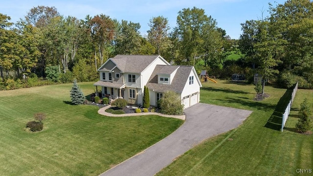 view of front of property with a front yard, covered porch, a garage, and driveway