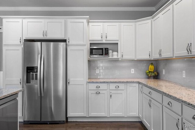 kitchen with white cabinetry, light stone countertops, dark hardwood / wood-style flooring, stainless steel appliances, and crown molding