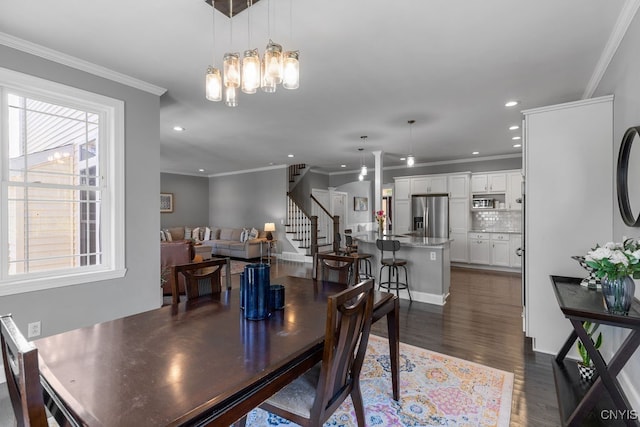 dining room with an inviting chandelier, crown molding, and dark hardwood / wood-style flooring