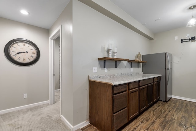 kitchen with dark hardwood / wood-style floors, dark brown cabinetry, and stainless steel fridge