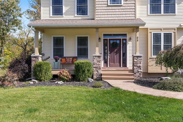 doorway to property with a lawn and covered porch