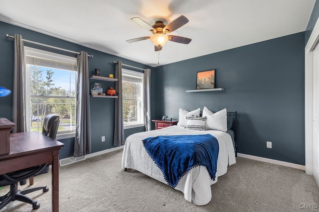 carpeted bedroom featuring multiple windows and ceiling fan