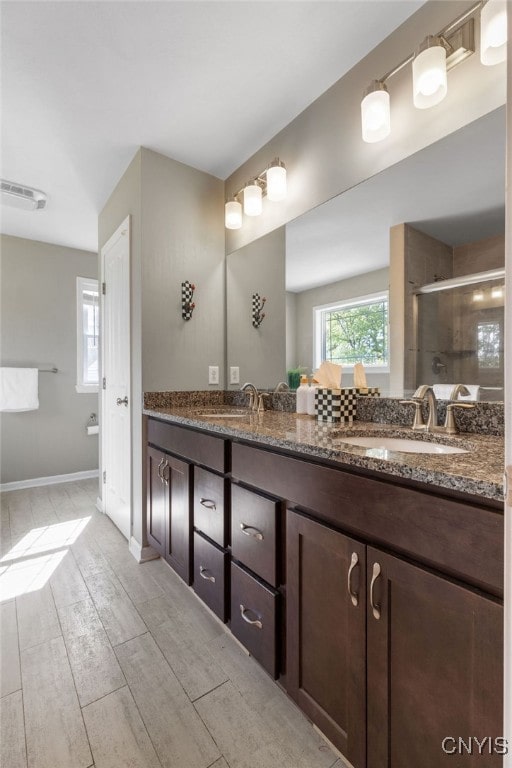 bathroom with vanity, a shower with shower door, and hardwood / wood-style floors