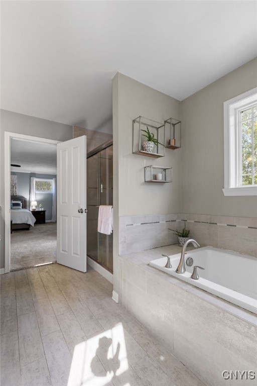 bathroom with plus walk in shower and hardwood / wood-style flooring