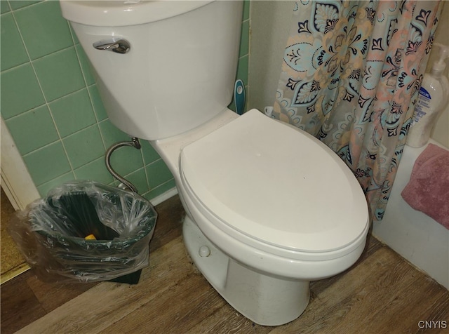 bathroom featuring tile walls, hardwood / wood-style flooring, and toilet