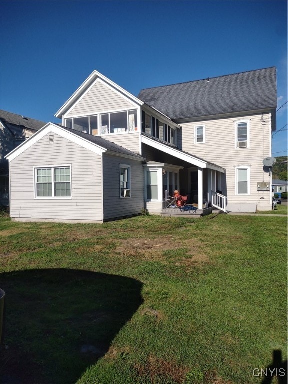 rear view of property with a lawn