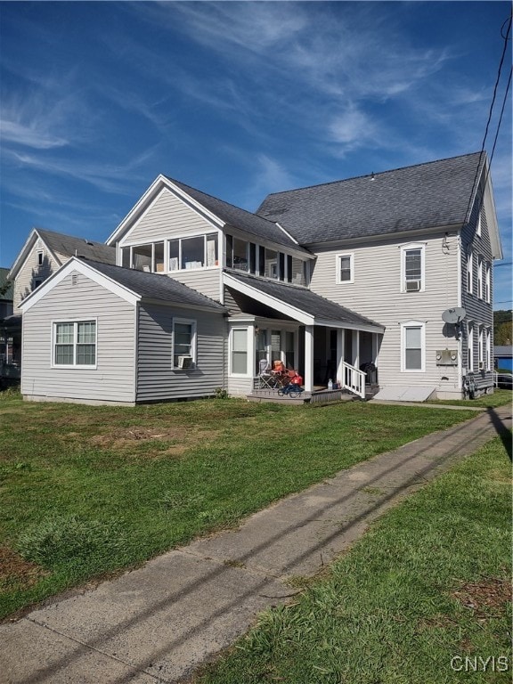 rear view of property with a lawn