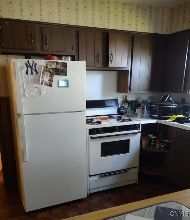 kitchen featuring white appliances and dark brown cabinetry