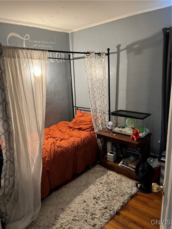 bedroom with wood-type flooring and crown molding