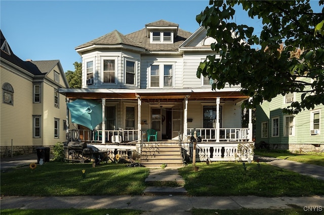 victorian house with a front lawn and a porch