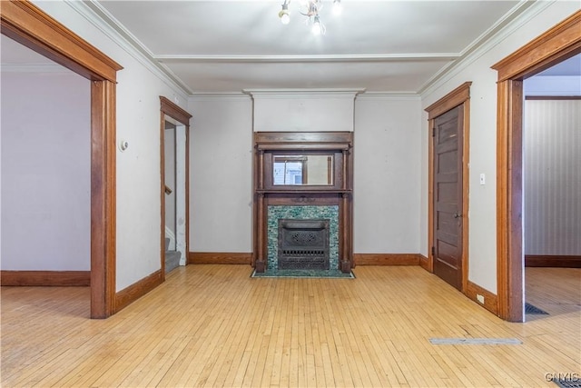 unfurnished living room featuring crown molding and light hardwood / wood-style floors