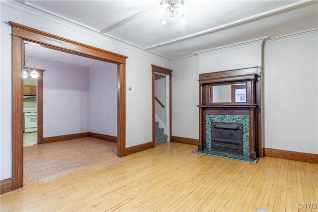 unfurnished living room featuring crown molding, a chandelier, and light wood-type flooring